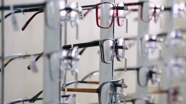 Optisyen perakende ortamı içindeki çoklu stil ve renk seçeneklerini vurgulayarak, çeşitli göz çerçevelerini döndüren profesyonel döner görüntü