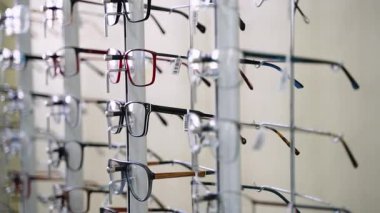 Bir optik mağazadaki ekran standında müşterilerin seçeceği farklı çerçeve biçimleri ve renkleri gösteren çeşitli gözlük dönüşleri
