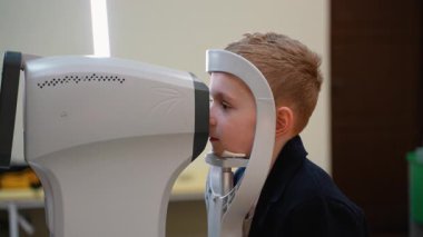 Klinik çevrede ileri seviye tanı teknolojisi kullanan, görme ve göz sağlığını dikkatlice inceleyen profesyonel bir sağlık uzmanı genç hastaya görüş değerlendirmesi yapıyor.