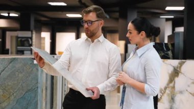 Fayans seçimi sürecinde kadın müşterilere rehberlik eder, çeşitli örnekler sunar ve çağdaş sergi ortamında uzman tavsiyeleri sunar