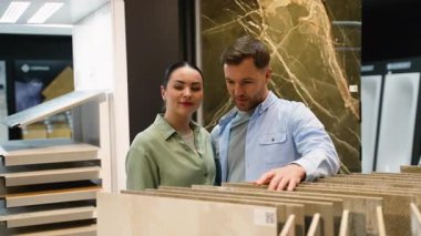 Çağdaş sergi ortamında ev yenileme için tasarım seçeneklerini araştırarak, genç çifte fayans seçim sürecinde rehberlik eden profesyonel iç mimar