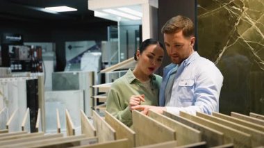 Profesyonel danışman, modern bir sergi salonunda uzman tavsiyesi ve rehberlik sunarak, ev yenileme projesi için fayans seçmelerine yardımcı oluyor.