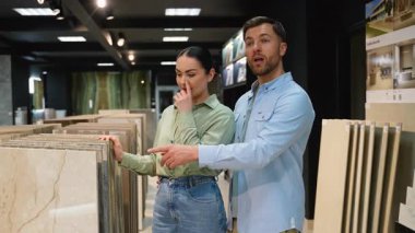 Profesyonel iç dizayn danışmanı, modern sergi salonunun yenilenmesi için gerekli materyalleri seçmelerine yardımcı olarak, fayans seçim sürecinde çifte rehberlik ediyor.