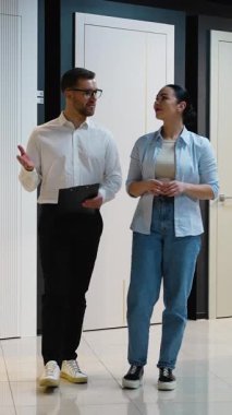 Profesyonel danışmanlar modern showroom 'da çift ile kapı modellerini tartışıyor ve ev tasarımı seçimi için uzman rehberliği sağlıyorlar.