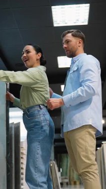 Genç çift dairelerini yenilemek için seramik fayanslar seçiyor, galeride satış asistanına danışıyor, seçenekleri tartışıyor ve kararlar alıyorlar.