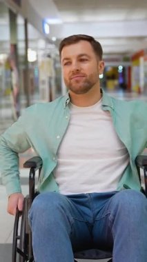 Yetkili tekerlekli sandalye kullanıcısı alışveriş merkezi koridorunda rahatça dolaşır, kişisel özgürlüğü tecrübe eder ve pozitif tutumla bağımsız hareket etmeyi benimser.