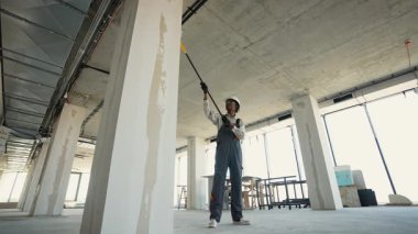 Haşere kontrol uzmanı koruyucu giysiler giyiyor ve yenilenmekte olan boş bir ofis binasında böcek ilacı sıkıyor ve gelecekteki kiracılara zararsız bir ortam sağlıyor.