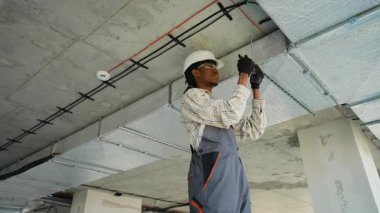 Yetenekli hvac teknisyeni titizlikle bir havalandırma sistemi kurarak, inşaat halindeki bir binada düzgün hava akışı ve iklim kontrolü sağlıyor.