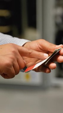 Perakende alışverişçisi giysi kalitesini incelerken ve giysi mağazası ortamında ürün özelliklerini değerlendirirken dikkatli bir şekilde etiketi inceler