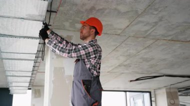 Üniformalı yetenekli teknisyen modern ofis havalandırma sistemi üzerinde çalışıyor, uygun hava dolaşımını ve bakım verimliliğini sağlıyor..