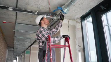 Tesisatçı yangın koruma borusu yerleştirir..