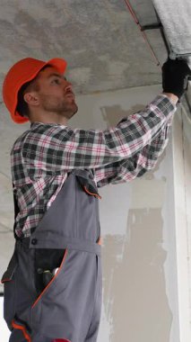 Teknik üniformalı deneyimli işçiler, temiz hava ve uygun hava akışı yönetimi sağlamak amacıyla modern bir ofise tavandan monte edilmiş havalandırma sistemi kuruyor..