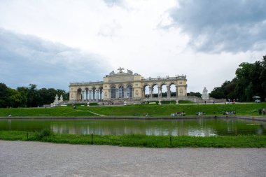 Viyana, Avusturya - 29 Temmuz 2025: Viyana spesiyaliteleri sunan klasik kafe terası. Bahçedeki yükseltilmiş bina, Gloriette sarayın mücevheri. Gloriette, Schloss Schnbrunn, 
