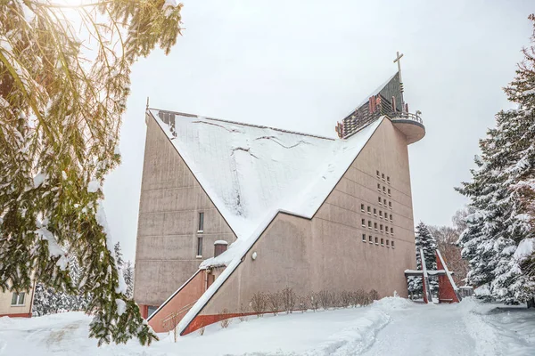 Poland, Krakow, 12.03.2023, snowfall, snowy church after a blizzard, avalanche danger, snow falling from the roof, plants and buildings covered with snow