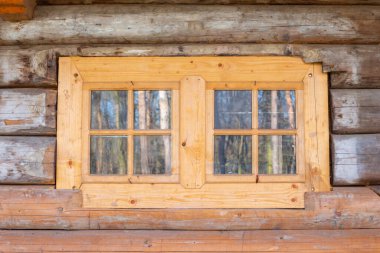 Eski ahşap bir evin duvarında küçük bir pencere.