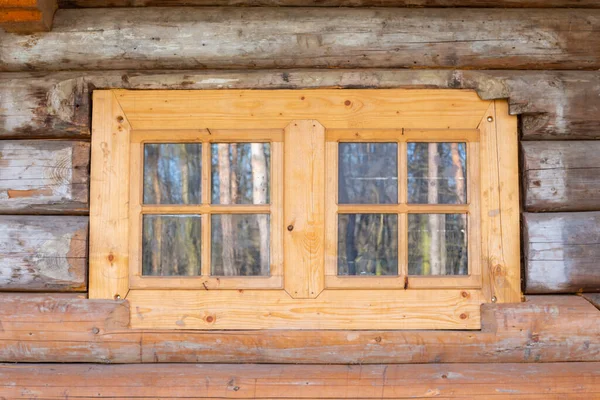 Eski ahşap bir evin duvarında küçük bir pencere.