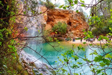 Huzurlu bir göl, kayalık uçurumlara kurulmuş gökyüzünü ve yemyeşil bitki örtüsünü yansıtır. Huzurlu bir geri çekilme yaratır..