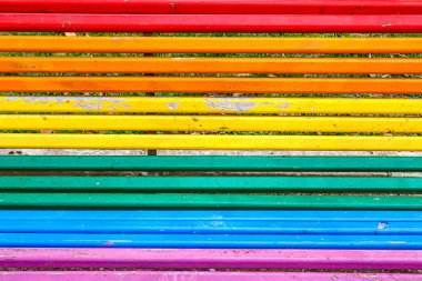 Parlak renkli çizgiler parkta bir bankı süslüyor, ziyaretçileri dinlenmeye ve dışarıda eğlenmeye davet ediyor..