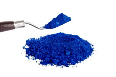 Canlı bir mavi pigment, sanatsal kullanım için canlı rengi harmanlamaya hazır bir karıştırma aracı ile bir yüzeyde bulunur..