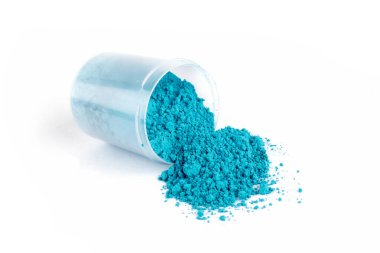 Parlak Mavi Toz Beyaz bir yüzeydeki şeffaf bir konteynırdan dökülüyor