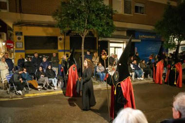 İspanya, Valencia, 29 Mart 2024: Geleneksel kıyafet yürüyüşüne katılanlar kalabalık bir caddede, etrafları izleyiciler ve atmosferik aydınlatmalarla çevrili olarak katıldılar..