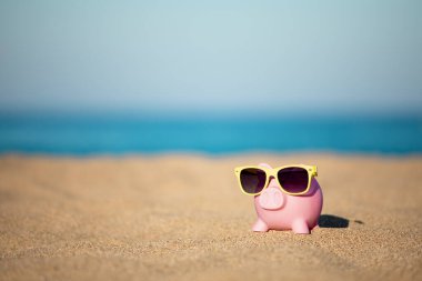 Kumsaldaki kumsalda, deniz ve gökyüzü arka planına karşı. Yaz seyahati ve tatil konsepti için tasarruf
