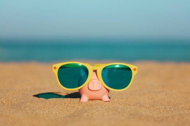 Kumsaldaki kumsalda, deniz ve gökyüzü arka planına karşı. Yaz seyahati ve tatil konsepti için tasarruf