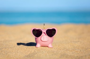 Kumsaldaki kumsalda, deniz ve gökyüzü arka planına karşı. Yaz seyahati ve tatil konsepti için tasarruf