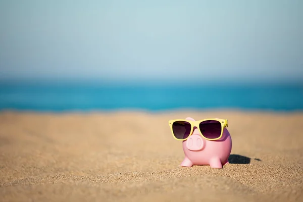 stock image Piggybank on the beach against sea and sky background. Savings for summer travel and vacation concept