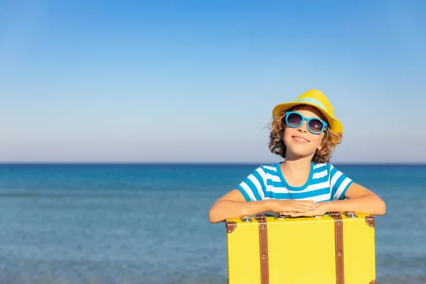 夏休みにヴィンテージのスーツケースを着た子供 ビーチで遊んでいる女の子 子供は海と空の背景に座っている 旅と冒険のコンセプト — ストック写真