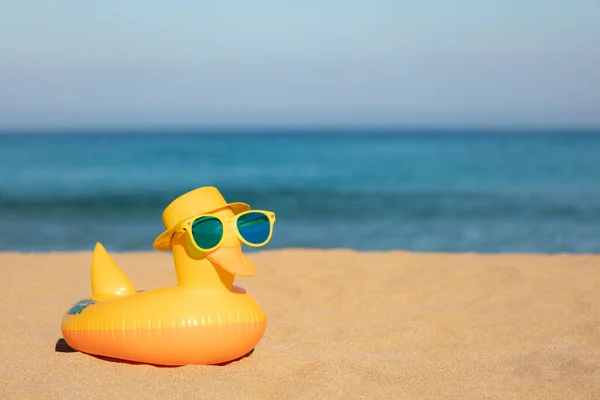 滑稽的黄鸭 头戴沙滩帽 戴着太阳镜 背对着蓝色的大海和天空 暑假和旅行概念 — 图库照片