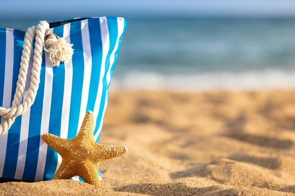海滩袋和海星在蓝色的大海和天空的背景下 暑假的概念 — 图库照片