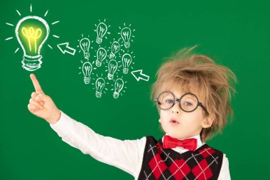 Sınıftaki komik çocuk öğrenci. Yeşil karatahtaya karşı mutlu çocuk. Eğitim konsepti. Okula geri dön.