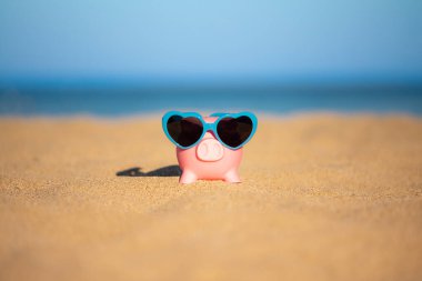 Kumsaldaki kumsalda, deniz ve gökyüzü arka planına karşı. Yaz seyahati ve tatil konsepti için tasarruf