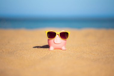 Kumsaldaki kumsalda, deniz ve gökyüzü arka planına karşı. Yaz seyahati ve tatil konsepti için tasarruf