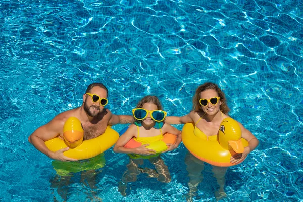 幸せな家族は屋外プールで遊んでいます 夏休みを楽しんでいる人たち 健康的なライフスタイルのコンセプト — ストック写真
