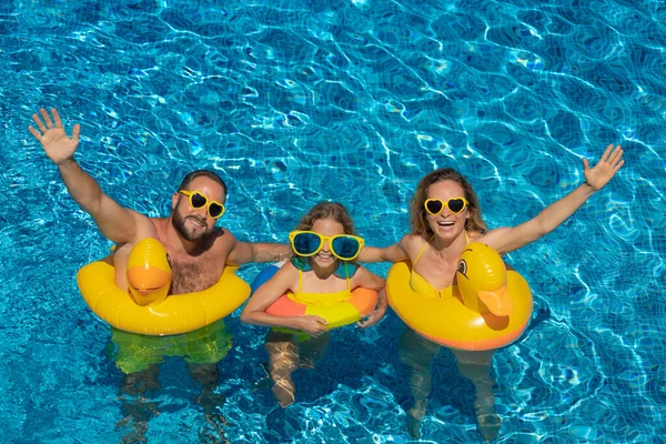 幸せな家族は屋外プールで遊んでいます 夏休みを楽しんでいる人たち 健康的なライフスタイルのコンセプト — ストック写真