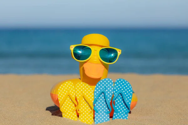 Пляжные Флип Флопы Желтая Утка Песке Фоне Синего Моря Неба — стоковое фото