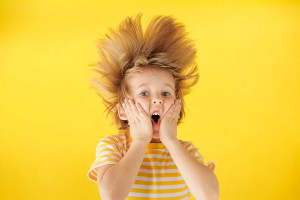 Uma Criança Surpresa Segurar Rosto Miúdo Chocado Contra Fundo Amarelo — Fotografia de Stock