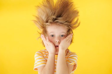 Surat asan süpriz çocuk. Sarı arka planda şok olmuş bir çocuk. Çizgili gömlek giyen bir çocuk. Yaz tatili ve seyahat konsepti