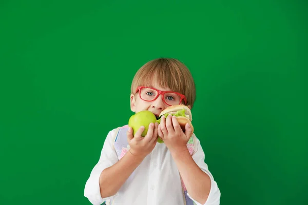 ハンバーガーとアップルをクラスで面白い子供の学生 緑の黒板に対して幸せな子供 教育と学校の概念に戻る — ストック写真