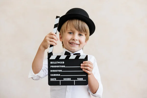 导演对着墙的后面大喊 男孩在家里玩 穿着老式服装的孩子 拿着拍手器的孩子社交媒体和因特网神经工作概念 — 图库照片