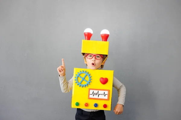 ロボットを着た幸せな子供 面白い子に考えがある 創造的かつ革新的な技術コンセプト — ストック写真