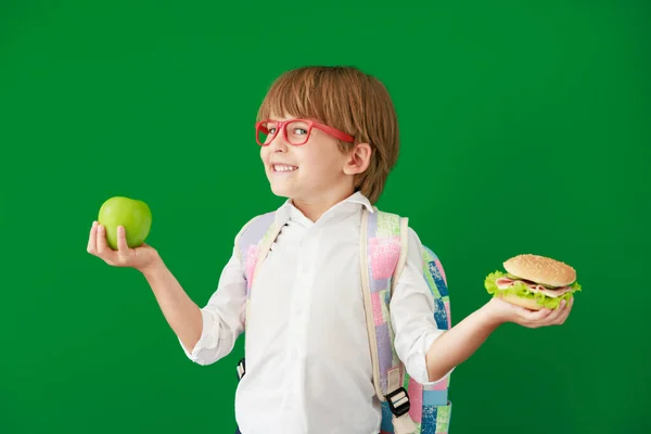 Sınıfta Hamburger Elma Yiyen Komik Bir Çocuk Yeşil Karatahtaya Karşı — Stok fotoğraf