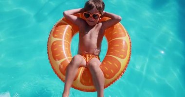 Happy child having fun on summer vacation. Kid playing in swimming pool. Active healthy lifestyle concept. Slow motion
