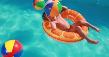 Happy child having fun on summer vacation. Kid playing in swimming pool. Active healthy lifestyle concept. Slow motion