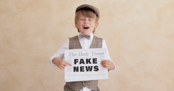 报童在混凝土墙的背景下大喊 卖假新闻的男孩穿着老式服装的孩子 小孩拿着报纸慢动作 — 图库视频影像