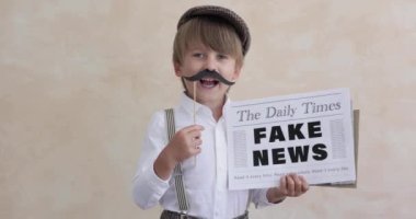 Newsboy shouting against concrete wall background. Boy selling fake news. Child wearing vintage costume. Kid holding newspaper. Slow motion