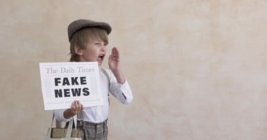 Newsboy shouting against concrete wall background. Boy selling fake news. Child wearing vintage costume. Kid holding newspaper. Slow motion