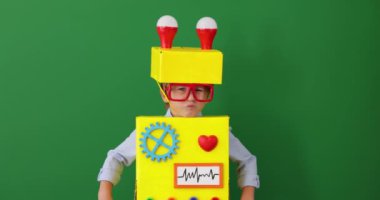 Happy child wearing toy robot. Funny kid playing at home. Success, creative and innovation technology concept. Slow motion